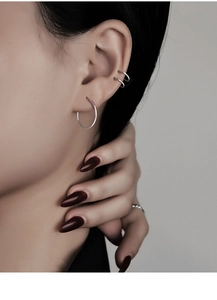 Close-up of a silver S925 sterling silver hoop earring and matching ear cuffs on a model