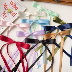 Detailed close-up of colorful satin ribbon bow hair clips in multiple vibrant shades