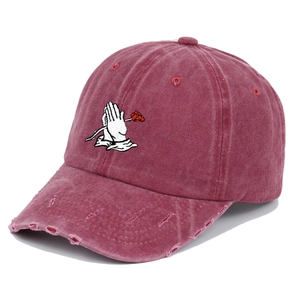 Detail of vintage washed baseball cap featuring prayer hands rose embroidery and distressed brim
