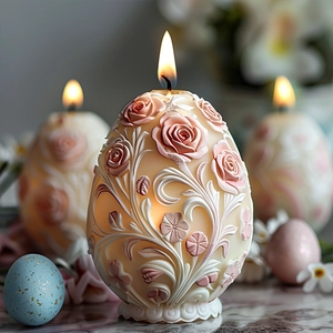 Macro di candela a forma di uovo con rilievo di rose e fiamma accesa su base di marmo