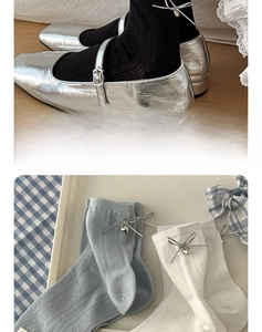 Détail de chaussettes résille style ballet avec nœud métallique argenté et cœurs