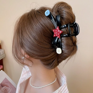 Rear view of black acrylic hair claw clip with star buttons on brown hair updo