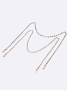 Golden eyewear chain set with black and white rhinestones on a minimalist background