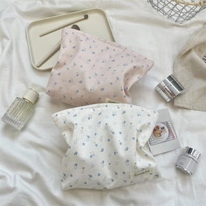 Close-up of floral cotton cosmetic bags in pink and cream with blue flower patterns