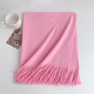 Detail of pink cashmere-like scarf showing soft texture and delicate fringe trim