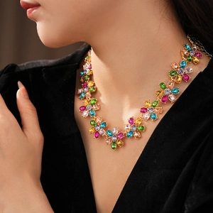 Close-up of a vintage luxury colorful floral necklace worn by a model in black V-neck clothing