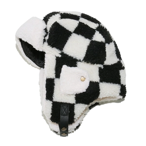 Macro detail of checkerboard lamb wool trapper hat showing metal buckle and faux leather strap