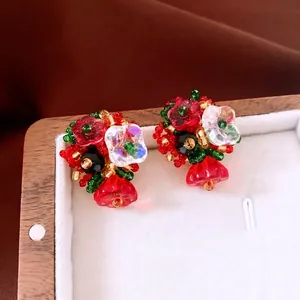 Vintage handmade floral beaded earrings with red and green crystals in a jewelry box