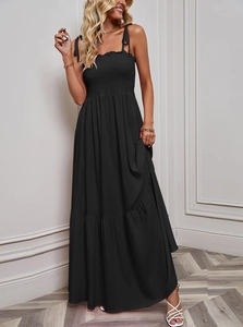 Detailed view of the layered tier skirt and pleated bodice on this black strapless maxi dress