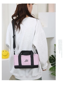 Detailed back view of model wearing pink and black nylon crossbody barrel bag
