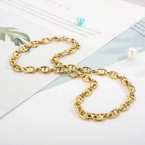 Detail shot of golden stainless steel pig nose link necklace on a decorative background