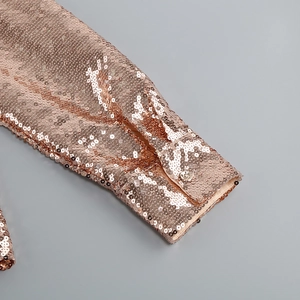 Detailed macro view of high-density rose gold sequins and cuff texture of a two-piece set