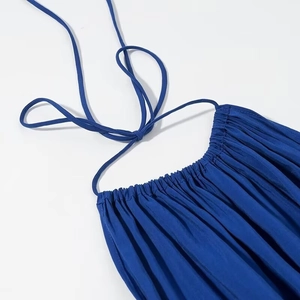 Detail view of the navy blue halter neckline and ruched fabric on this midi dress