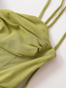 Dettaglio di un top a fascia verde lime con trama a pieghe e spalline sottili