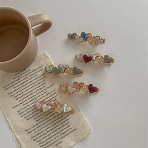 Set of five retro heart-shaped acetate hair clips in assorted colors with gold metal base