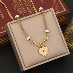 Golden heart necklace with blue eye design and crystal chain on jewelry display