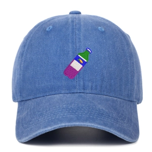Detailed embroidery of a green beverage bottle on a navy blue washed cotton baseball cap