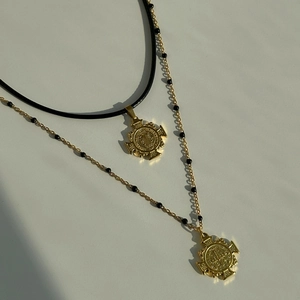18K gold plated titanium cross necklaces with black cord and beaded chain on white background