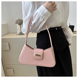 Detailed close-up of a pink leather underarm baguette bag with golden metal hardware
