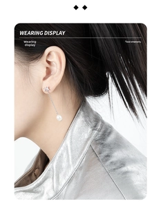Close-up of elegant tassel pearl earrings with square zircon on a stylish model