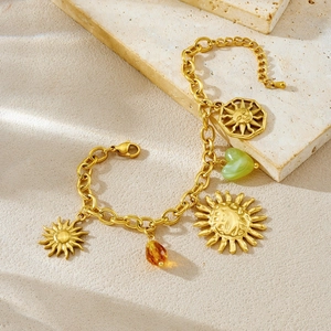 Bohemian gold stainless steel charm bracelet with sun, green heart, and amber drop pendants