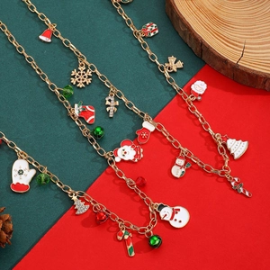 Détail du collier de Noël avec breloques en émail coloré sur fond festif rouge et vert