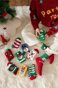Close-up of cozy Christmas coral fleece socks in festive colors on a soft white rug