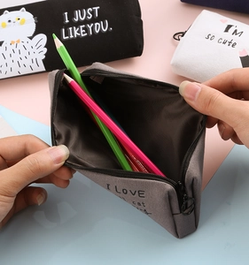 Close-up of grey canvas pencil case being opened showing interior storage capacity