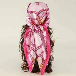 Pink silk square scarf with chain pattern worn as a headscarf on a model