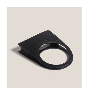 Minimalist black leather handbag with circular handle and structured geometric design