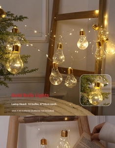Detail of 10 gold Christmas bulb lights showing 6x10cm size and AA battery power source