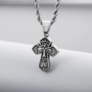 Macro detail of silver vintage cross pendant with Jesus head and rope chain