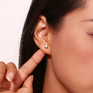Minimalist stainless steel stud earrings with white zircon on ear in a close-up view