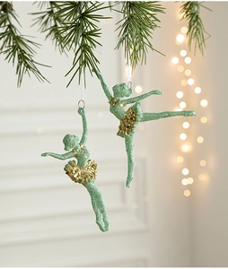 Close-up of two mint green ballet girl ornaments with gold sequins for Christmas trees