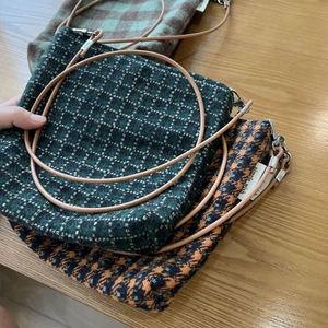 Detailed close-up of colorful tweed plaid fabric textures and crossbody straps on mini bags
