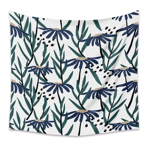 Detail of bohemian tapestry featuring blue daisies and green leaves on white background