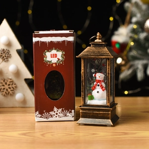 Close-up of bronze LED Christmas lantern featuring a snowman figurine with gift box