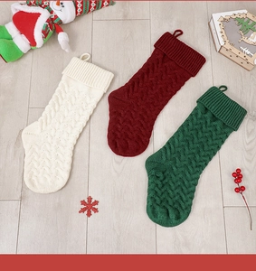 Detailed knit texture of white, red and green Christmas stockings on wooden floor