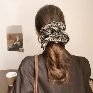 Detail shot of a double-layered leopard print scrunchie on hair for a retro fashion look