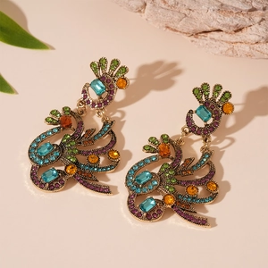 Close-up of vintage bronze peacock earrings with colorful rhinestones and intricate metalwork