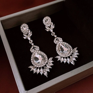 Macro shot of silver drop earrings with marquise rhinestones in a luxury jewelry box
