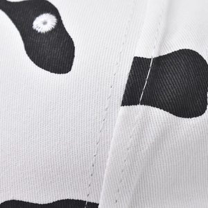 Detailed close-up of cow print cotton fabric texture and stitched eyelets on a baseball cap