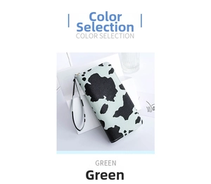 Detail of green cow print wallet featuring gold zipper and matching wrist strap