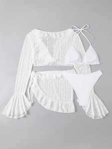 Flat lay of white lace four-piece bikini set with long sleeve cover-up and ruffles