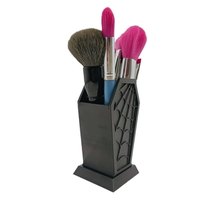 Gothic coffin-shaped makeup brush holder with spider web relief pattern on white background