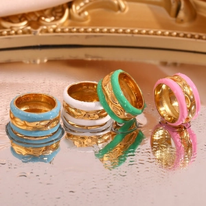 Macro shot of colorful enamel rings in blue green pink on a reflective water surface