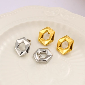 Detailed view of polished hexagonal hoop earrings in gold and silver finishes