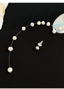 Detailed view of natural freshwater pearl earrings on black background with shells