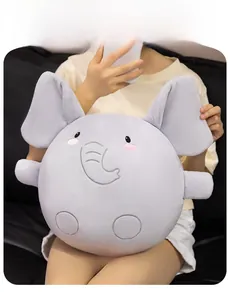 Close-up of a soft grey plush elephant toy with pink cheeks and embroidery details