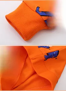 Detail of orange sweatshirt showing ribbed cuffs and high-quality knit texture finish